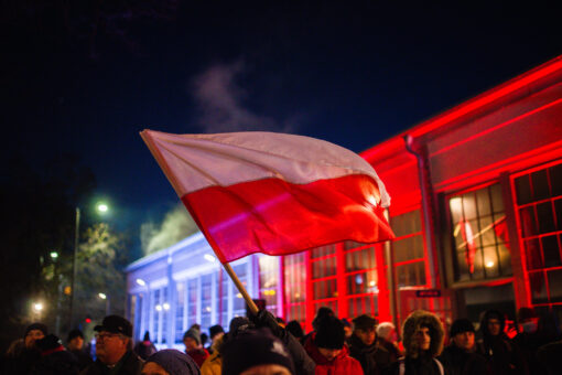 26. grudnia relacja z wydarzenia "Przyjazd Paderewskiego do Poznania" inscenizacja wydarzenia historycznego. widok dworca podświetlonego na biało-czerwono. Na pierwszym planie flaga narodowa: biało-czerwona.